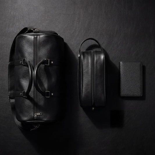 Zwarte leren laptoptas en accessoires naast elkaar