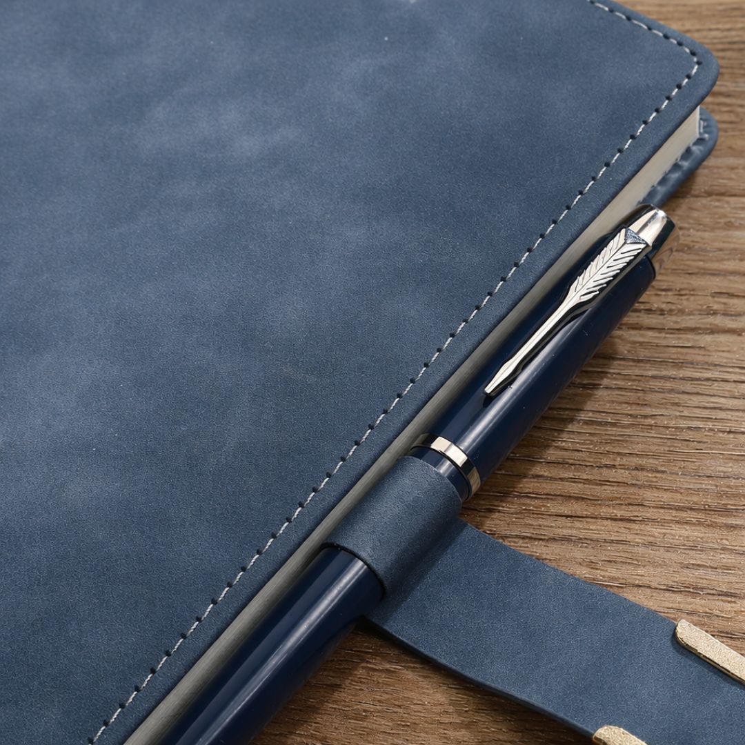 Notitieboek blauw met pen, schuin aanzicht